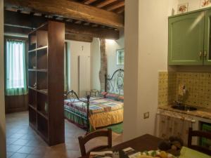 una cucina con una camera da letto con un letto e un tavolo di San Fedele Alloggi a Siena