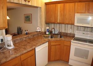 a kitchen with wooden cabinets and a counter top at Summerhouse 228 Condo in Saint Augustine +30 photos