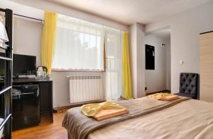 a bedroom with a bed and a window with yellow curtains at Guest House Slunchev Cviat in Tsigov Chark +37 photos