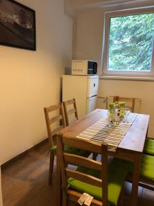 a kitchen with a table and chairs and a refrigerator at Sportarena & Stadion Apartman H-39 in Budapest