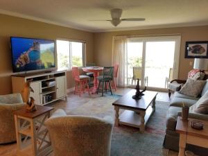 una sala de estar con un sofá y una mesa en Summerhouse 101 Condo, en St. Augustine