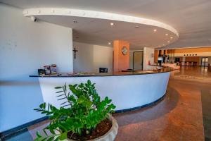 a lobby with a counter and a plant in a pot at Sol Praia Ayambra in Natal