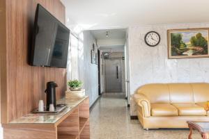 a living room with a couch and a clock on a wall at Hotel Itaipu in Goiânia