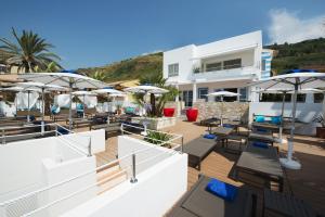 un resort con tavoli, sedie e ombrelloni di Piccolo Grand Hotel a Pizzo