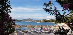 a beach with umbrellas and a body of water at Delight Hotel in Ksamil
