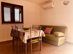 Un comedor con una mesa y un sofá. en Siniscola Casa vacanze Olmo, en Siniscola 5 fotos más