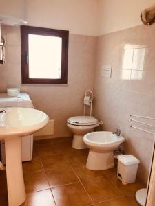 baño con lavabo y aseo y ventana en Siniscola Casa vacanze Olmo en Siniscola