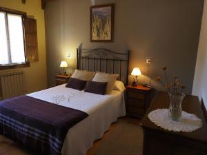 a bedroom with a large bed and two night stands at Hostal Almanzor Gredos in Navarredonda de Gredos