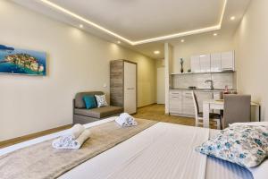 a bedroom with a large bed and a kitchen at Apolon Apart in Bar, Susanj