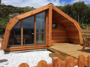 a large wooden cabin with a large window at Achmelvich View self catering in Lochinver