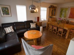 a living room with a black leather couch and a table at Town House close to Center in Reykjavík +16 photos