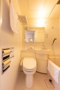 a bathroom with a toilet and a sink and a mirror at Sun Hotel Tosu Saga in Tosu