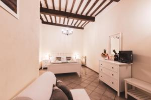 uma sala de estar com uma cama e uma televisão em Albergo Giardino em Montalcino