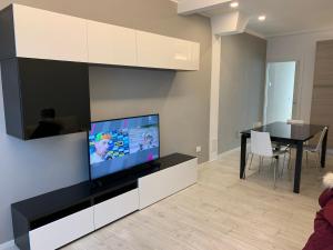 Una sala de estar con un televisor de pantalla plana y una mesa. en Il parco di Yuki (5), en Ancona