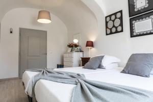 Duas camas num quarto com paredes brancas em Vintage Guest House - Casa do Escritor em Évora