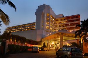 a large building with cars parked in front of it at Bogmallo Beach Resort in Bogmalo