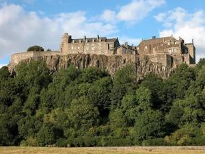 un castillo en la cima de una colina con árboles en The Victoria Inn Blythswood Snug, en Falkirk