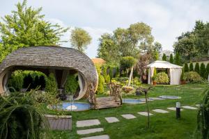 a garden with a gazebo in the grass at Diplomat Club Hotel in Chişinău