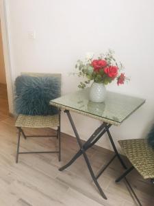 una mesa con un jarrón de flores y dos sillas en Guesthouse Dubrovnik, en Dubrovnik