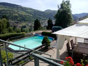 a swimming pool with a view of a mountain at Bellavie - Maison d'hôtes in La Bresse