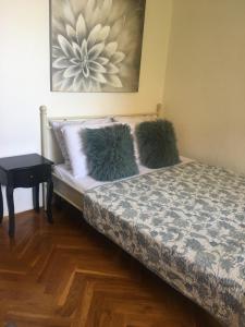 a bedroom with a bed with two pillows and a table at Guesthouse Dubrovnik in Dubrovnik