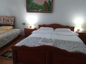 a bedroom with a large bed with two lamps on it at Pensiunea Casa Bradet in Statiunea Borsa