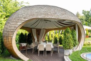 a round wooden gazebo with a table and chairs at Diplomat Club Hotel in Chişinău