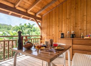 una sala da pranzo in legno con tavolo e balcone di French Coco a La Trinité