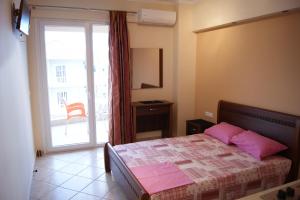 a bedroom with a bed with pink pillows and a window at Marie Claire Studios in Olympic Beach