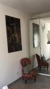 a room with a chair and a painting on the wall at Il Tenore d'Oro Centralissimo in Parma
