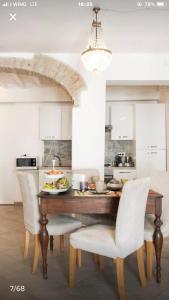 eine Küche mit einem Holztisch und weißen Stühlen in der Unterkunft Il Tenore d'Oro Centralissimo in Parma