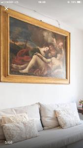 ein Gemälde an der Wand über einer Couch in der Unterkunft Il Tenore d'Oro Centralissimo in Parma