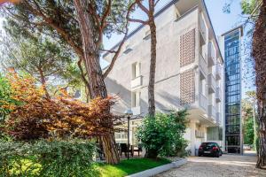 - une vue sur l'extérieur d'un bâtiment avec des arbres dans l'établissement Hotel Meublè Zenith, à Lignano Sabbiadoro