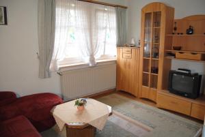 a living room with a table and a tv at Gut Dankerode in Dankerode