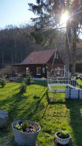 une maison dans une cour avec deux seaux de fleurs dans l'établissement Hexenhaus am Waldesrand Wernigerode, à Wernigerode