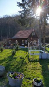ein Haus in einem Hof mit zwei Eimern Blumen in der Unterkunft Hexenhaus am Waldesrand Wernigerode in Wernigerode