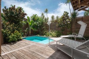 un patio trasero con piscina y terraza de madera en French Coco, en La Trinité