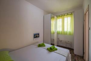 - une chambre avec un lit doté d'oreillers verts dans l'établissement Black and White chill out, à Komiža