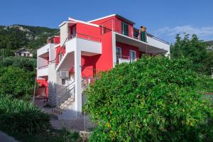 a red and white house with a tree at Black and White chill out in Komiža
