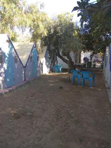 a group of blue benches sitting in a yard at Camping Koula in Parikia