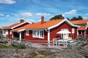 a red house with a table and an umbrella at Kvarnstugan in Mollösund