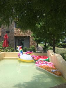 a swimming pool with three inflatable toys in it at Muho B&B in Dongshan