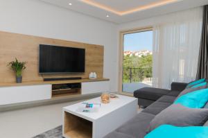sala de estar con sofá y TV en Villa Bondi, en Supetar