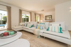 a living room with two white couches and a table at Casa Eleonora lifestyle Lodge in Lagos +47 photos