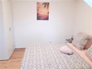sypialnia z łóżkiem z poduszką i plakatem w obiekcie MyHome Basel 3A46 w mieście Saint-Louis