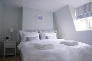 uma cama branca com duas toalhas em cima em Central Brighton Town House by MyHolidayLet em Brighton & Hove