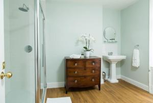 uma casa de banho com uma cómoda em madeira e um lavatório em Central Brighton Town House by MyHolidayLet em Brighton & Hove