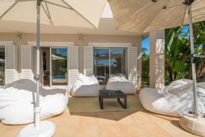 a patio with white chairs and an umbrella at Casa Eleonora lifestyle Lodge in Lagos