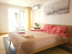 1 dormitorio con 1 cama grande con almohadas rojas en Boka Apartments, en Tivat