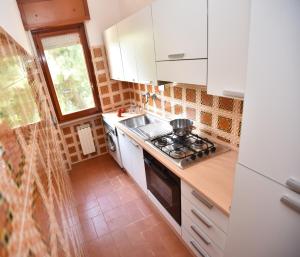 una piccola cucina con piano cottura e lavandino di Residence Blùmarine a Silvi Marina